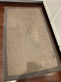 Soiled rug by kitchen sink