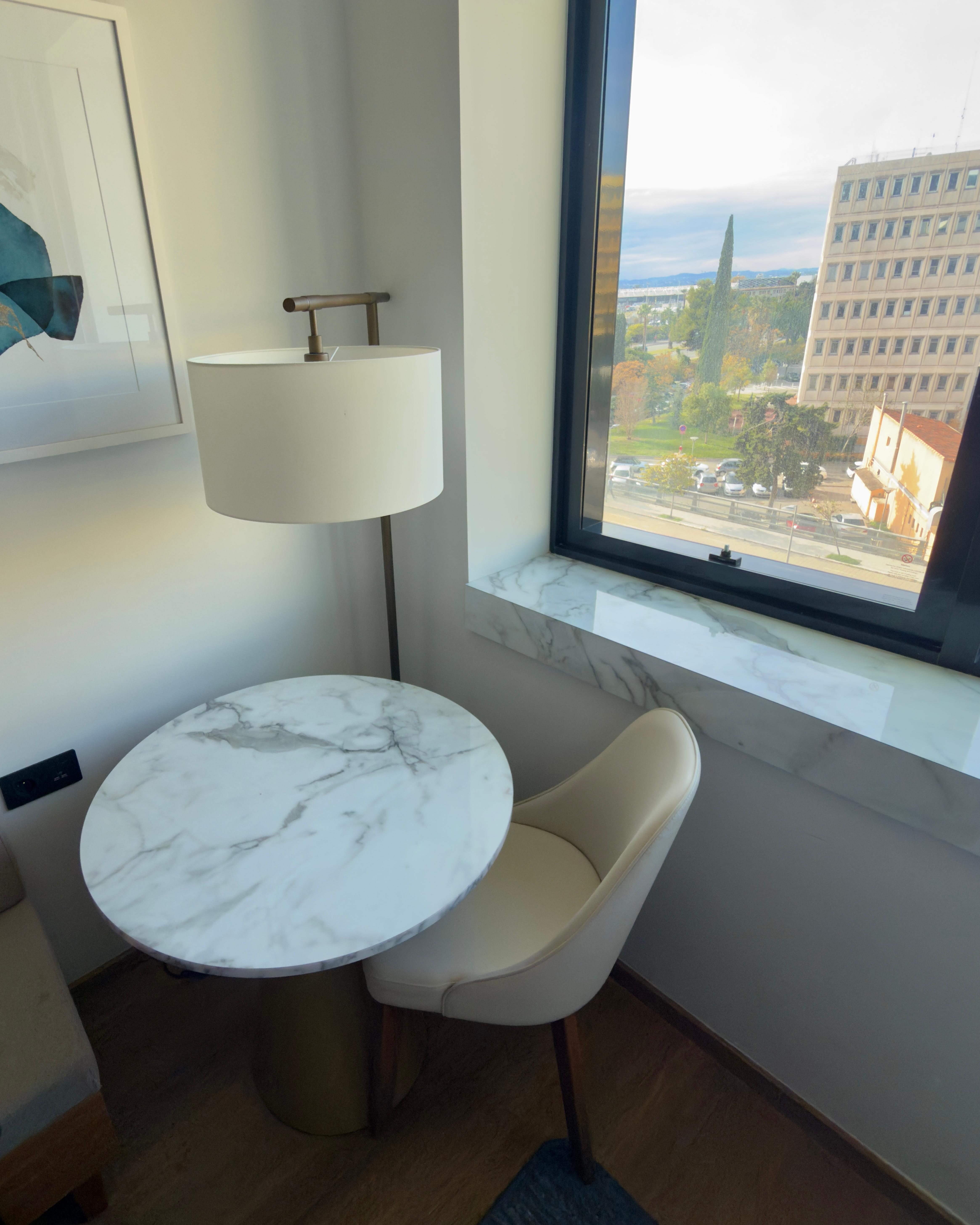 The chair and table by the window.