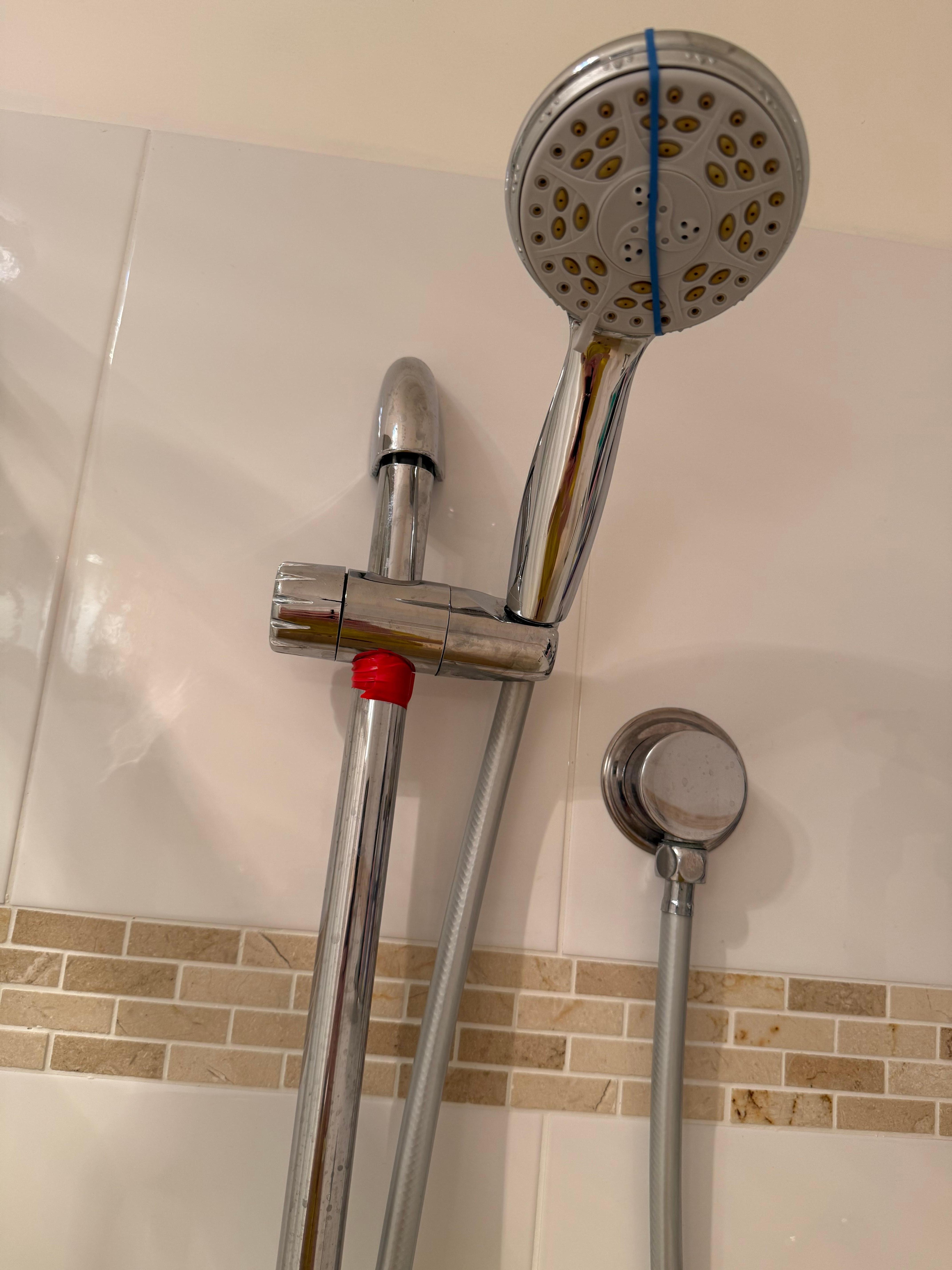 Worst shower head, red tape holding up, leaking & broken.