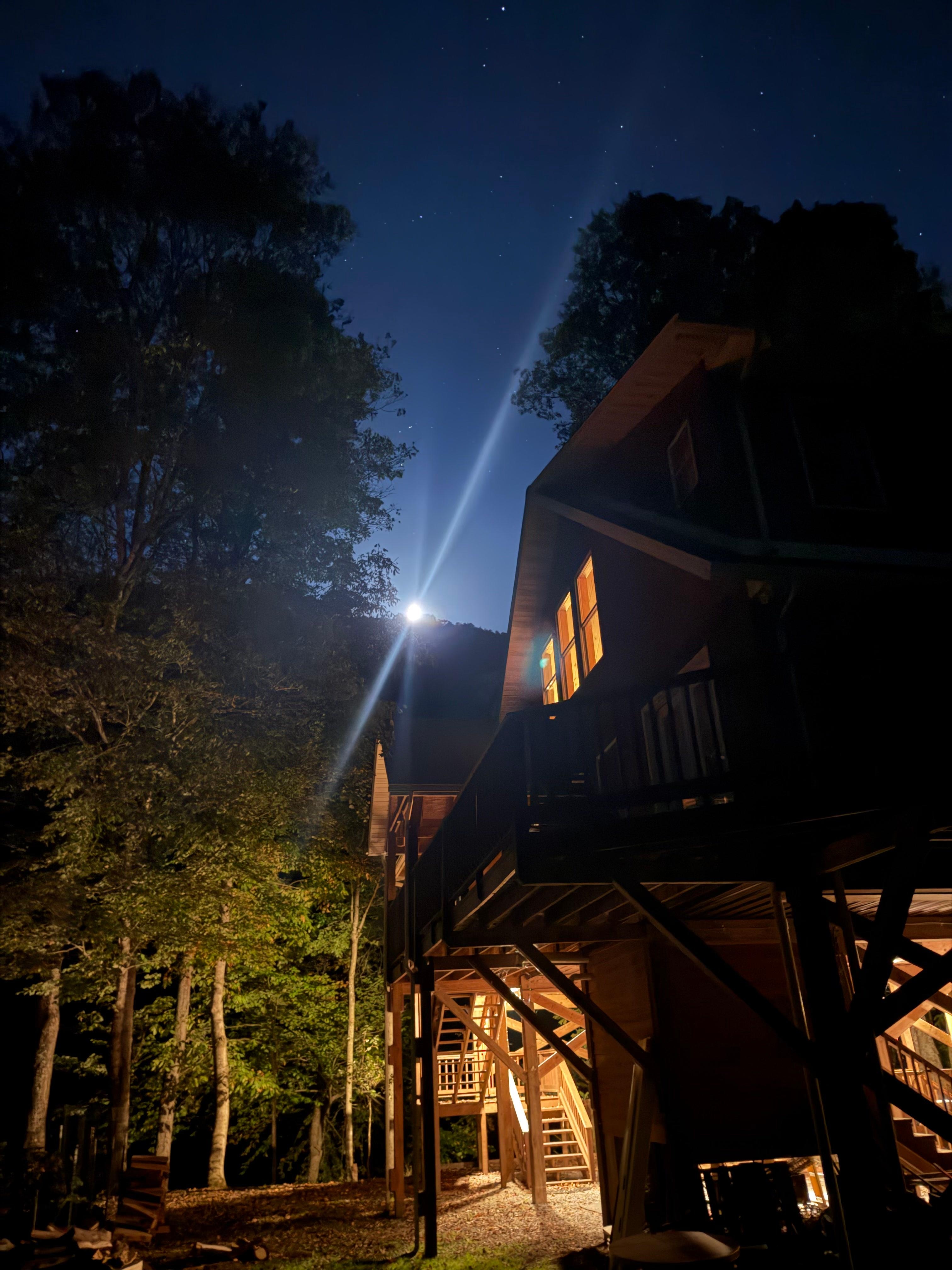 Moon rising over the ridge with the cabin in the foreground. 