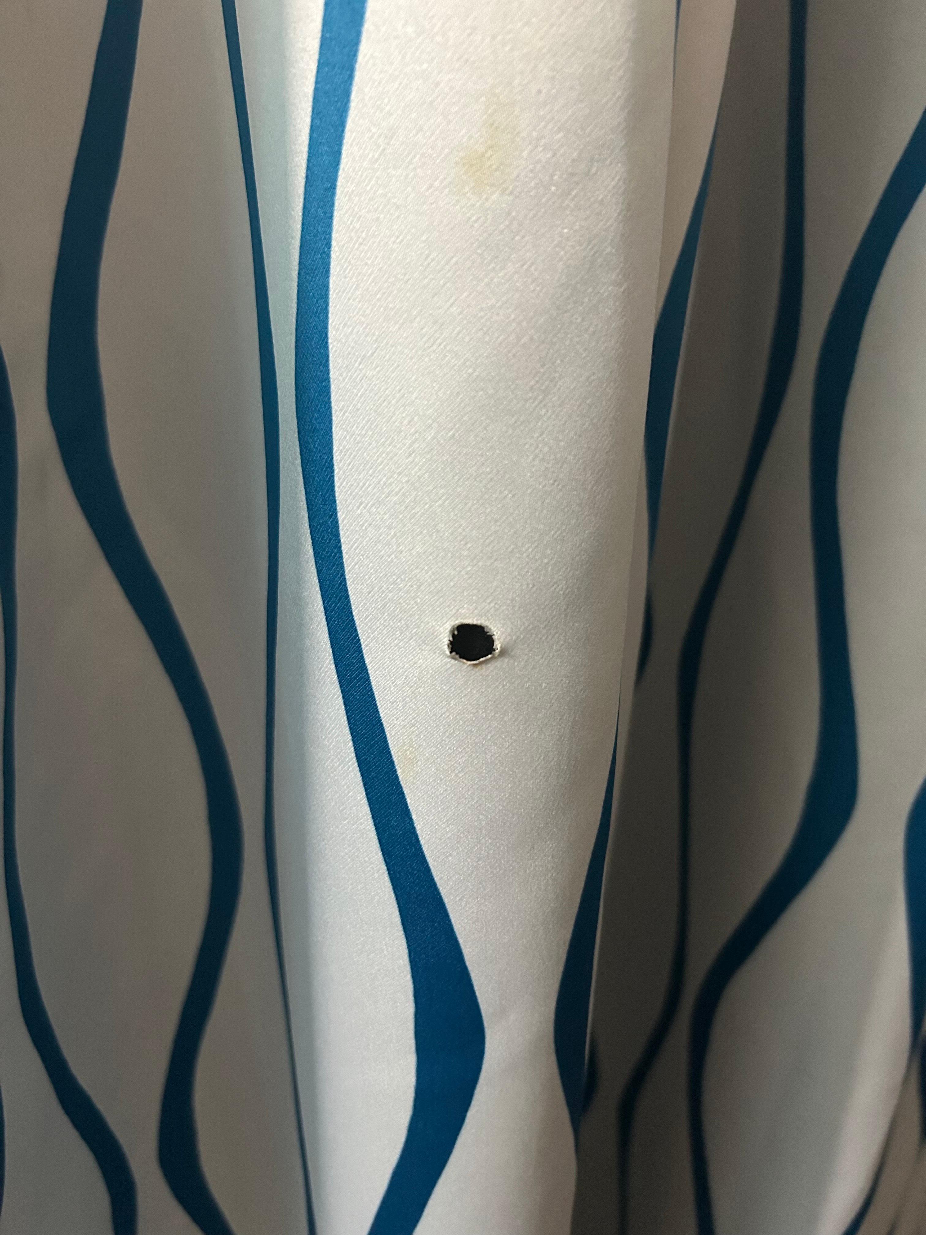 Cigarette burn hole in curtain.