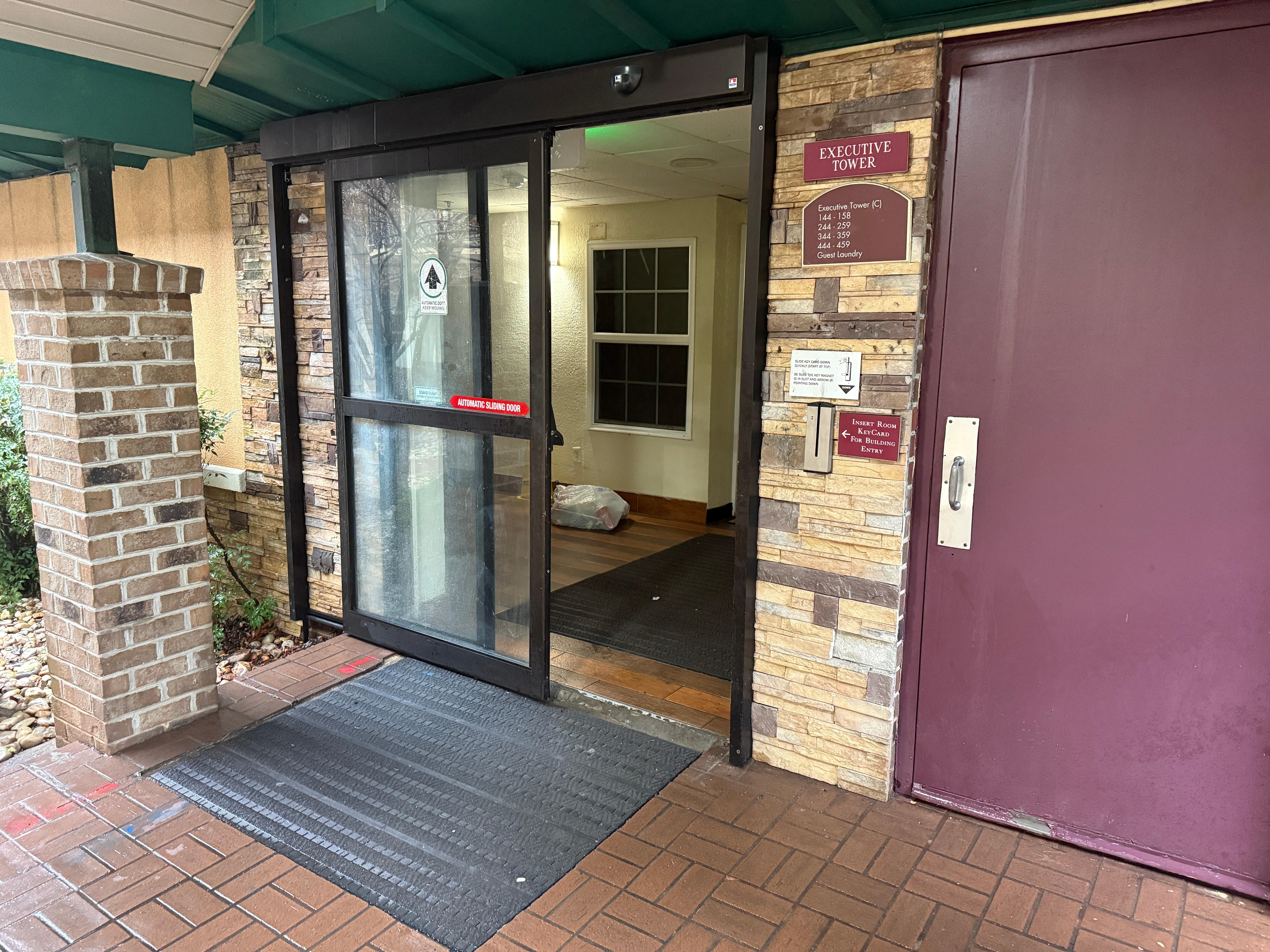 “Secure” entryway with broken door and trash. 