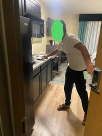 Employee looking at room we were given. Trash left in kitchen.