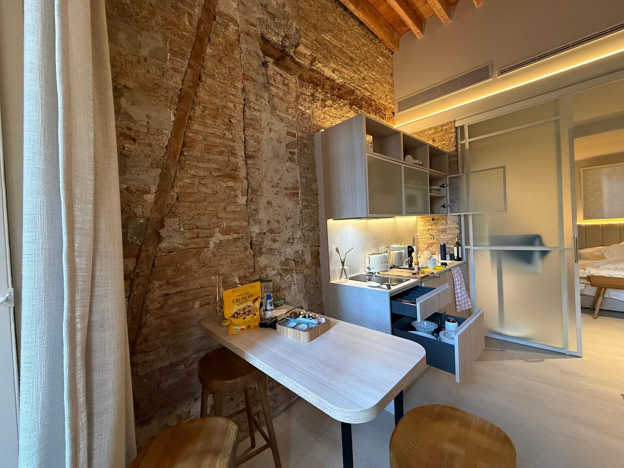 Dining, kitchen area with old walls exposed.