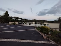 Grande terrasse qui surplombe la petite route d'accès et les prés