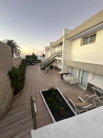 Blick von oben auf Terrasse, Apartmenteingang und das Meer.