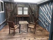 The charming deck off the kitchen. Steps lead down to the beach.