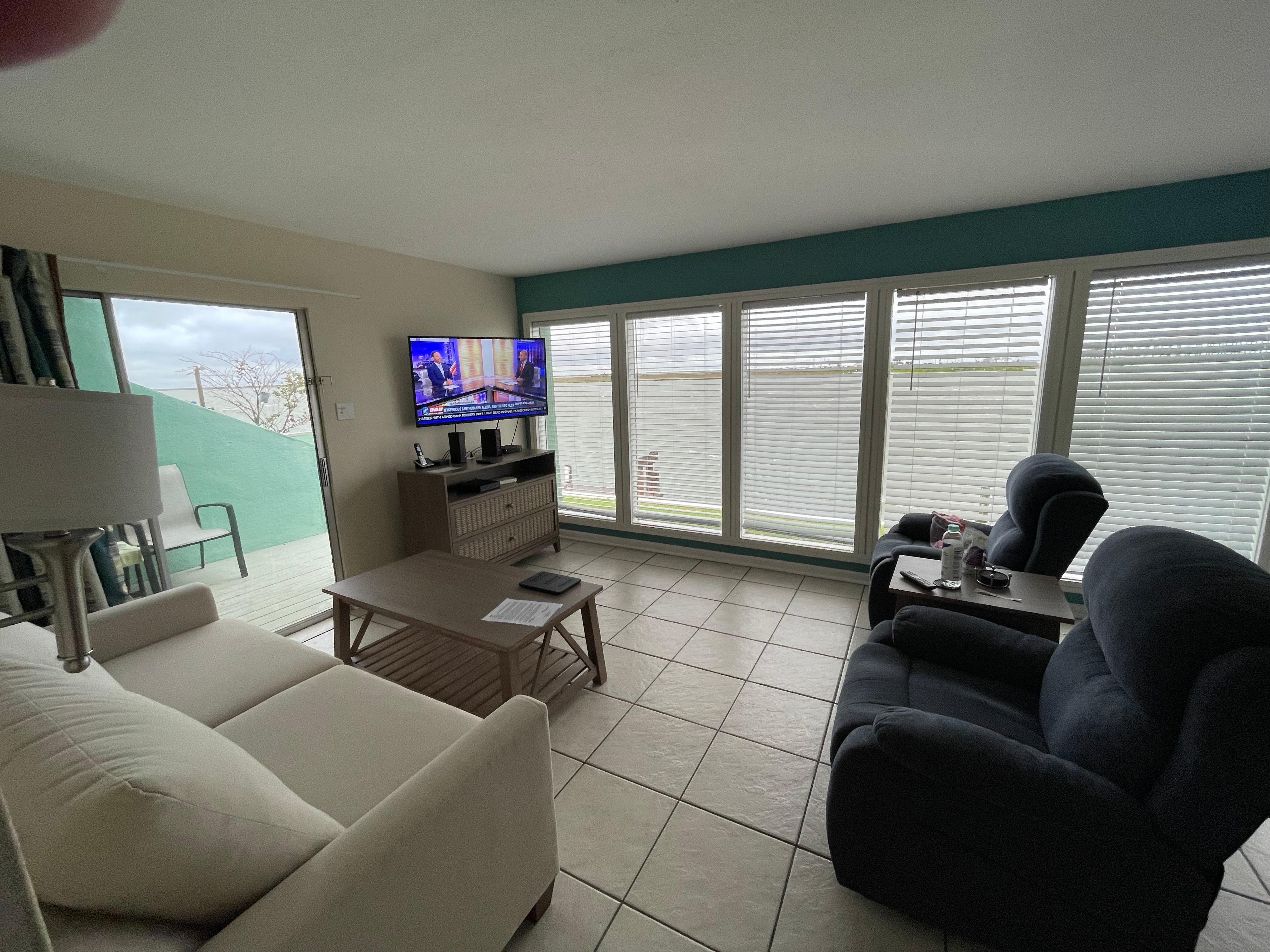 Tv and water views patio outside through sliding glass door to left of tv