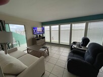 Tv and water views patio outside through sliding glass door to left of tv