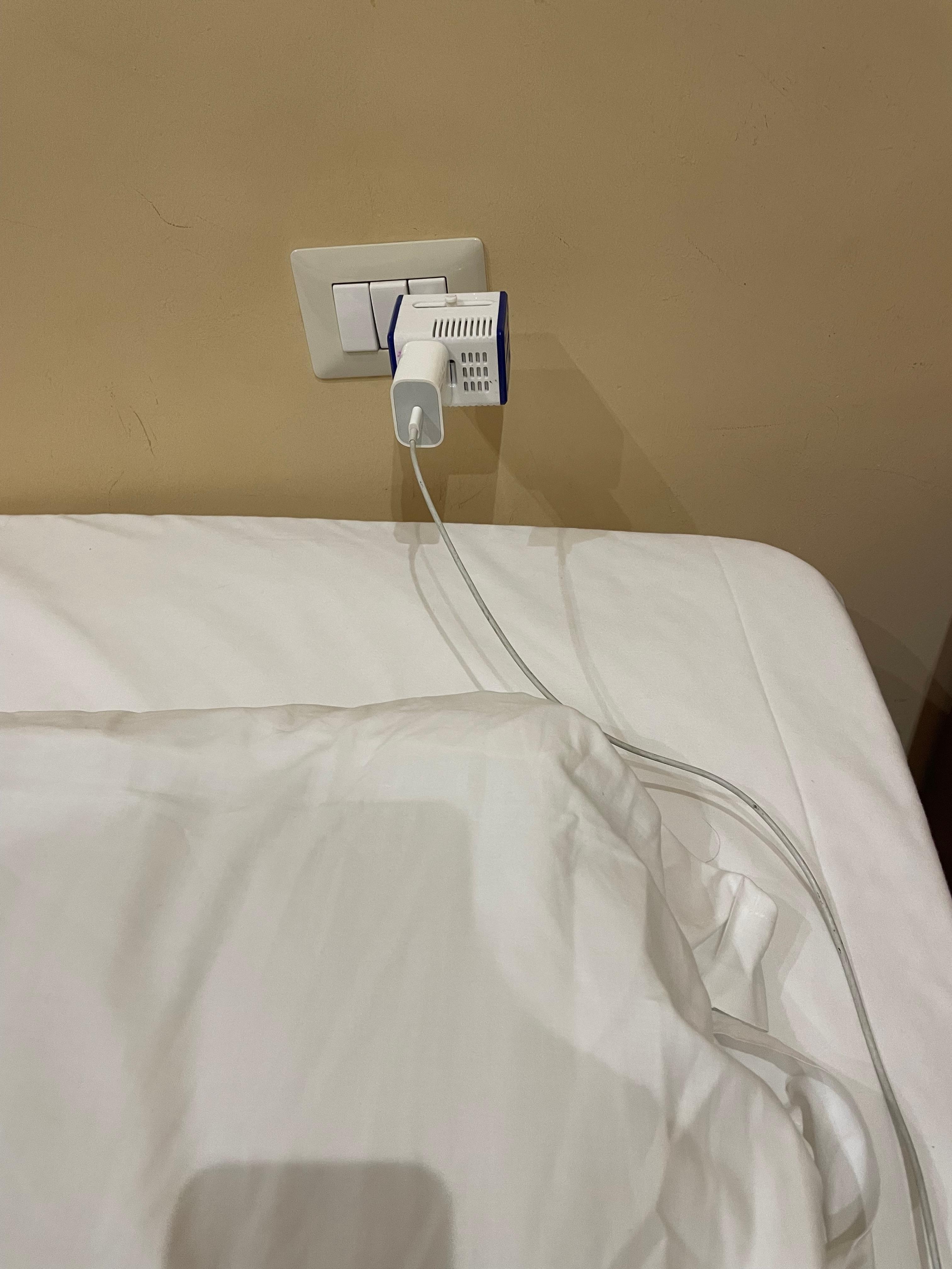 The outlet is right above the pillow/bed. 