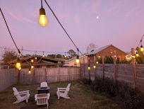 Partial view of Backyard with firepit, lights, and moon in sky. Perfect for stargazing!