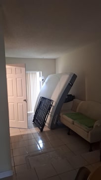 Dirty and stained mattress propped up against a extremely stained couch.