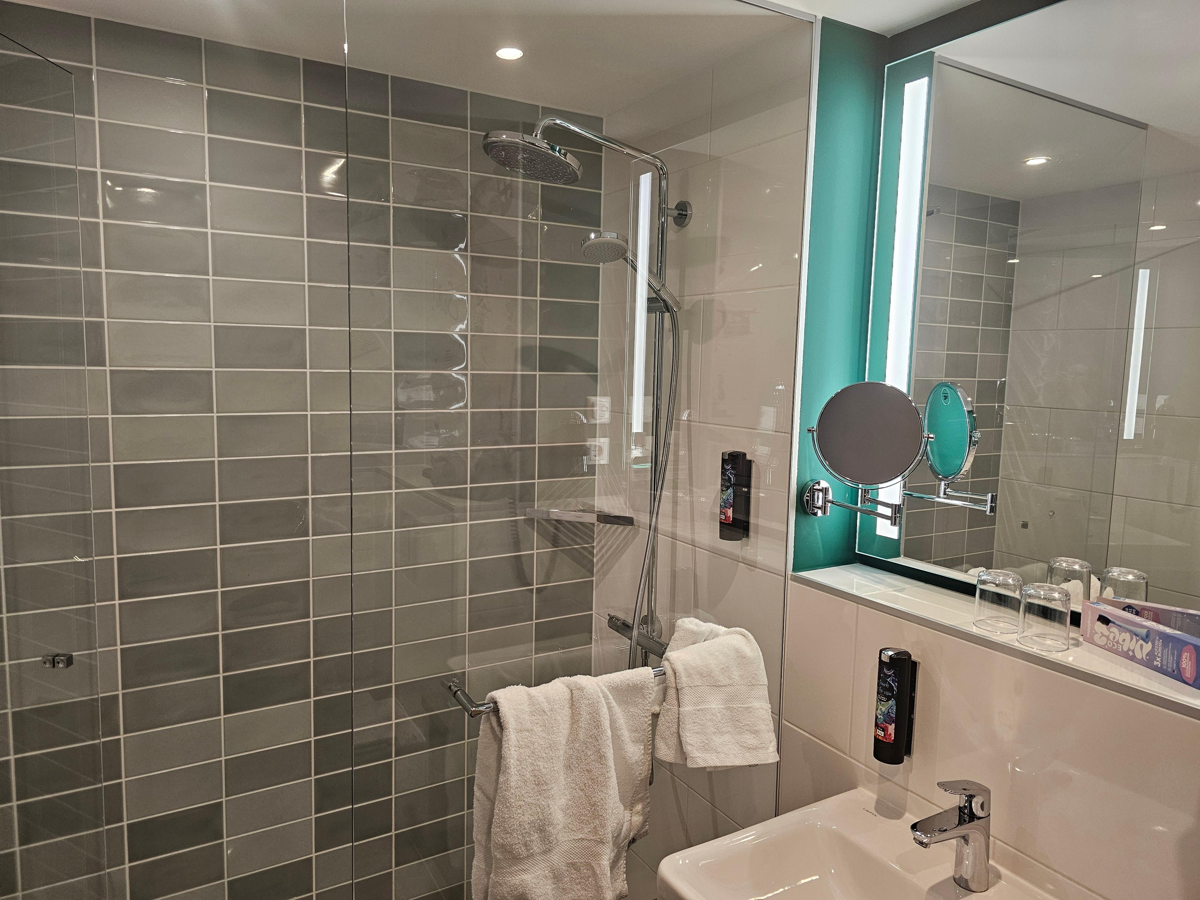 Geräumiges sauberes Badezimmer mit großer ebenerdiger Dusche.