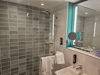 Geräumiges sauberes Badezimmer mit großer ebenerdiger Dusche.