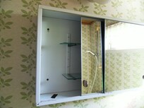 Ramponierter Spiegelschrank im Duschbereich