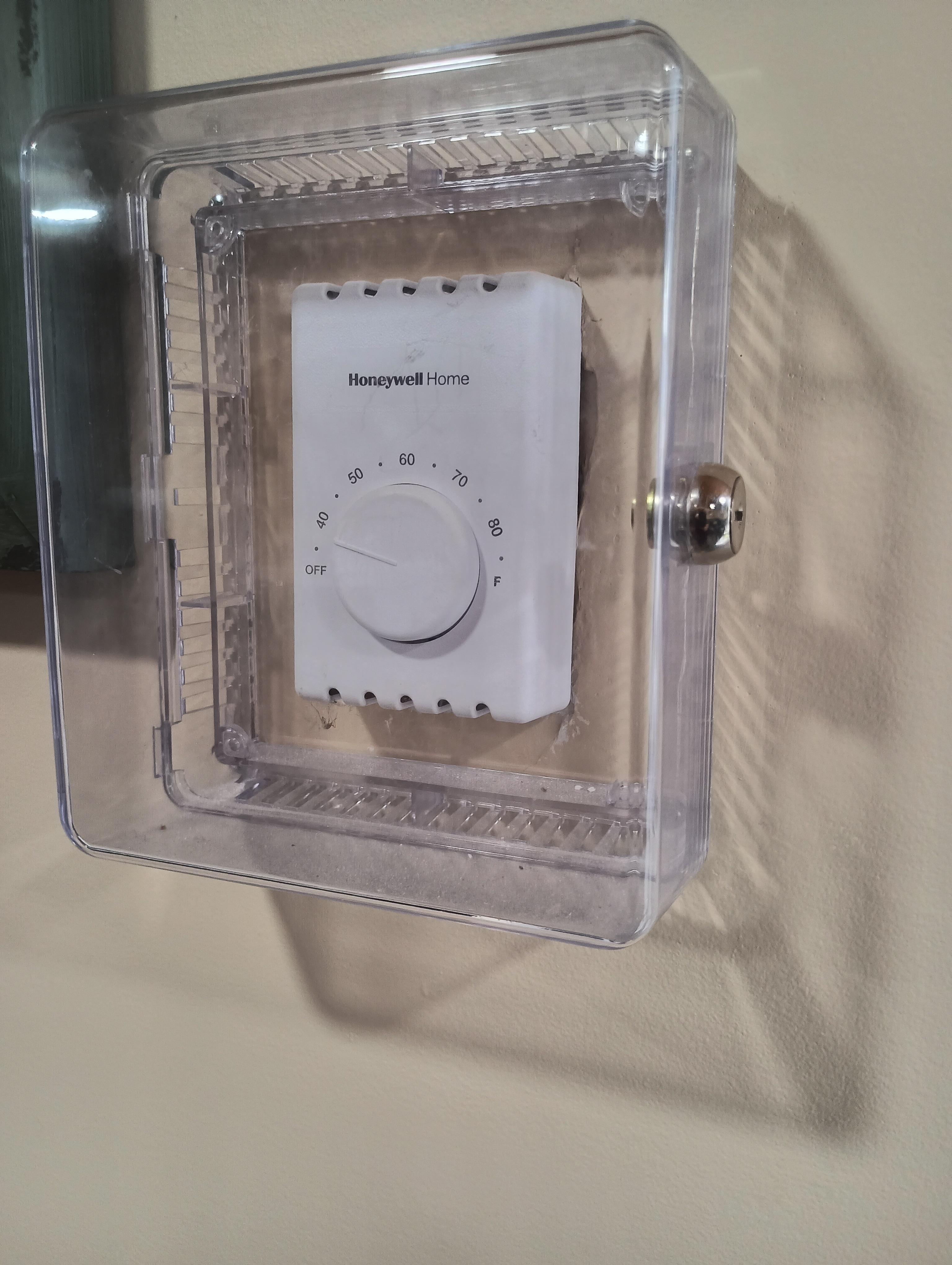 Locked thermostat for baseboard heat. (Gas heater thermostat was turned up as high as it would go.)