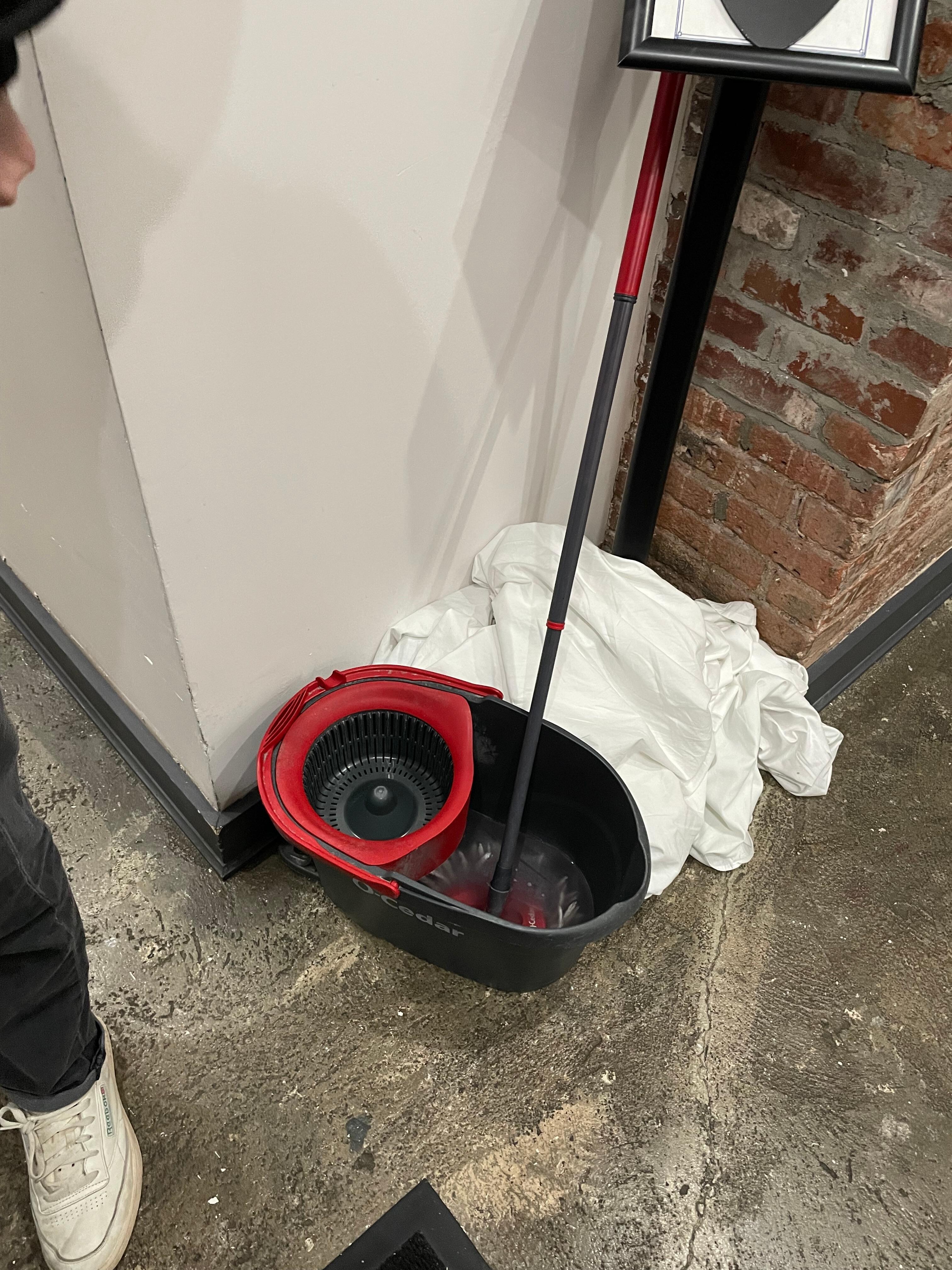 Mop and towels out on the floor in hallway 