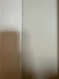 Layers of dust easily visible on some baseboards and doorframes.