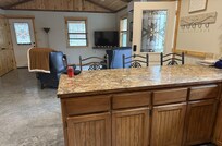 From kitchen looking toward living area. Front door on right, door to patio on left.