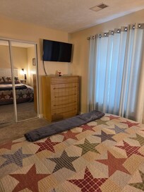 Bedroom with large closet, TV, and dresser