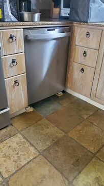 Broken wood holding up or leveling the dish washer