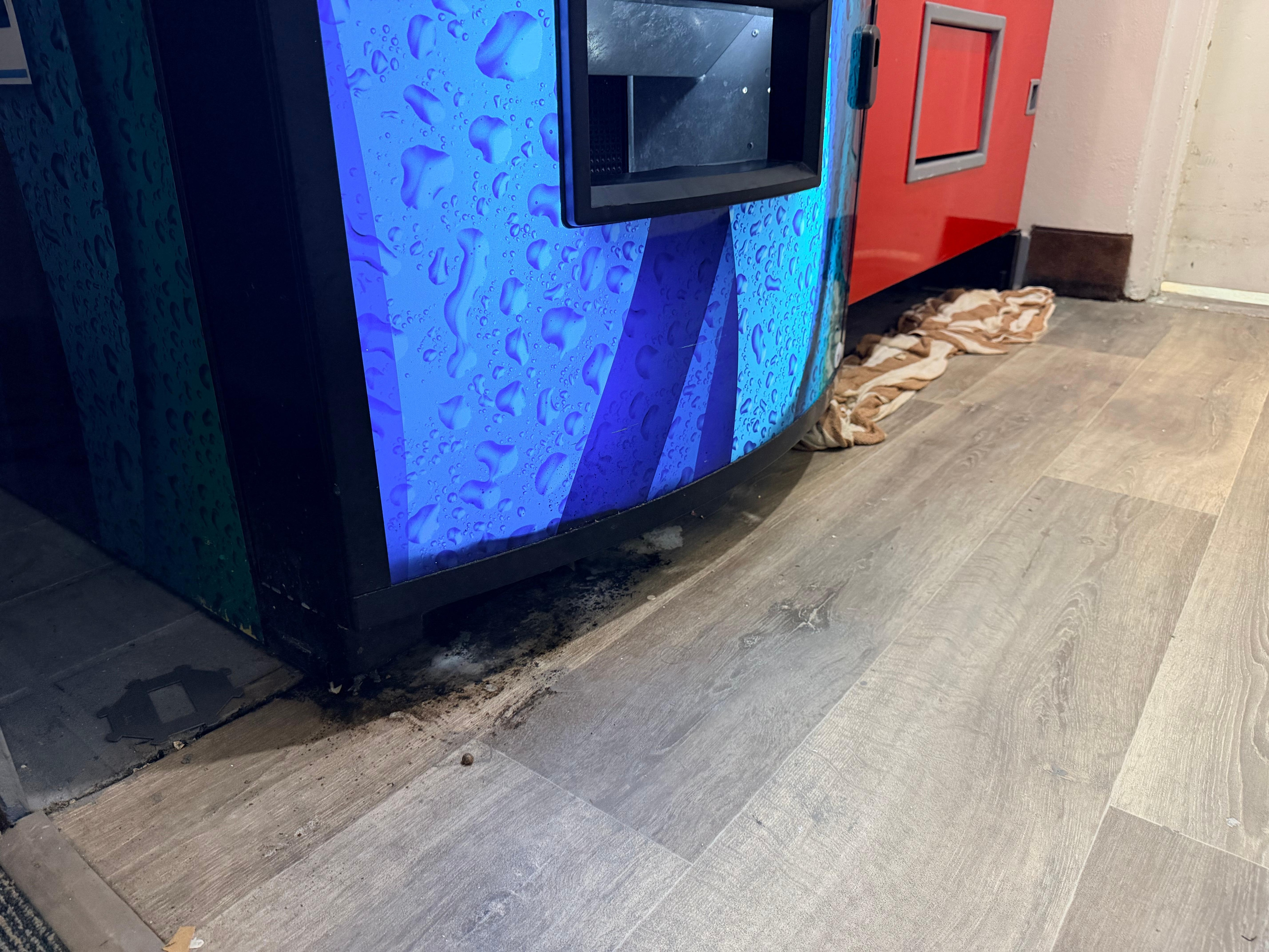 Las vending machine tienen hongo en el piso y una toalla recogiendo el liqueo