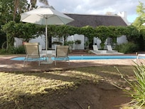 Manicured grounds overlooking grazing springbok, zebra and mongoose