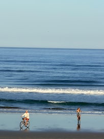 Family riding rental bikes on the beach!
