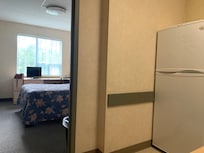 One of the bedrooms and full size fridge.