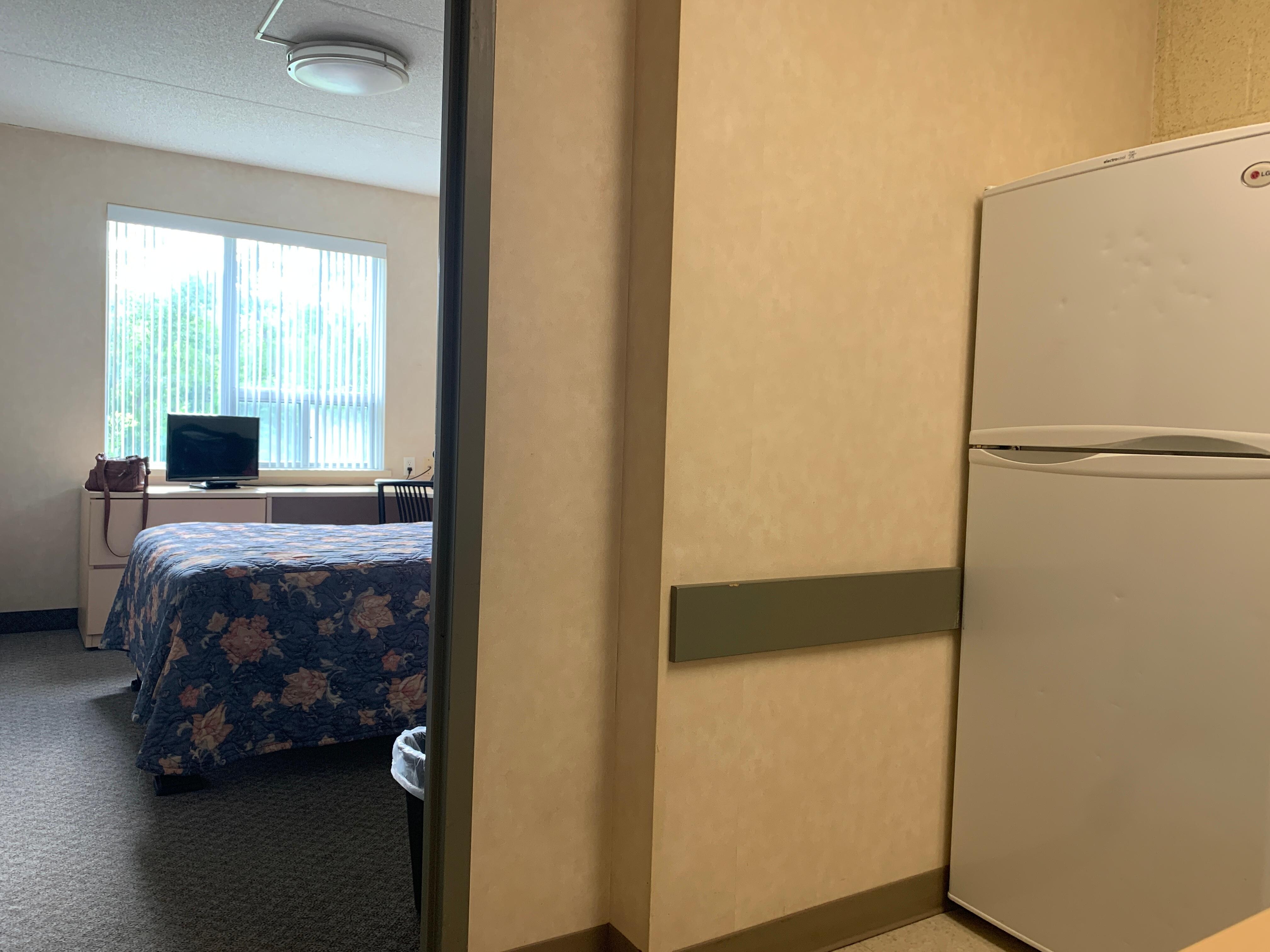 One of the bedrooms and full size fridge. 