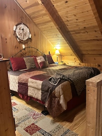 Loft with king bed and the edge of the railing