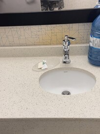 Big mirror and counter, tiny sink. Another tilted smaller mirror, for someone in a wheel chair to use.