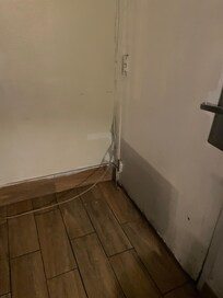 Looks like the door has been kicked in - wires hanging out of everywhere. Every inch of the room need repair/replacement.