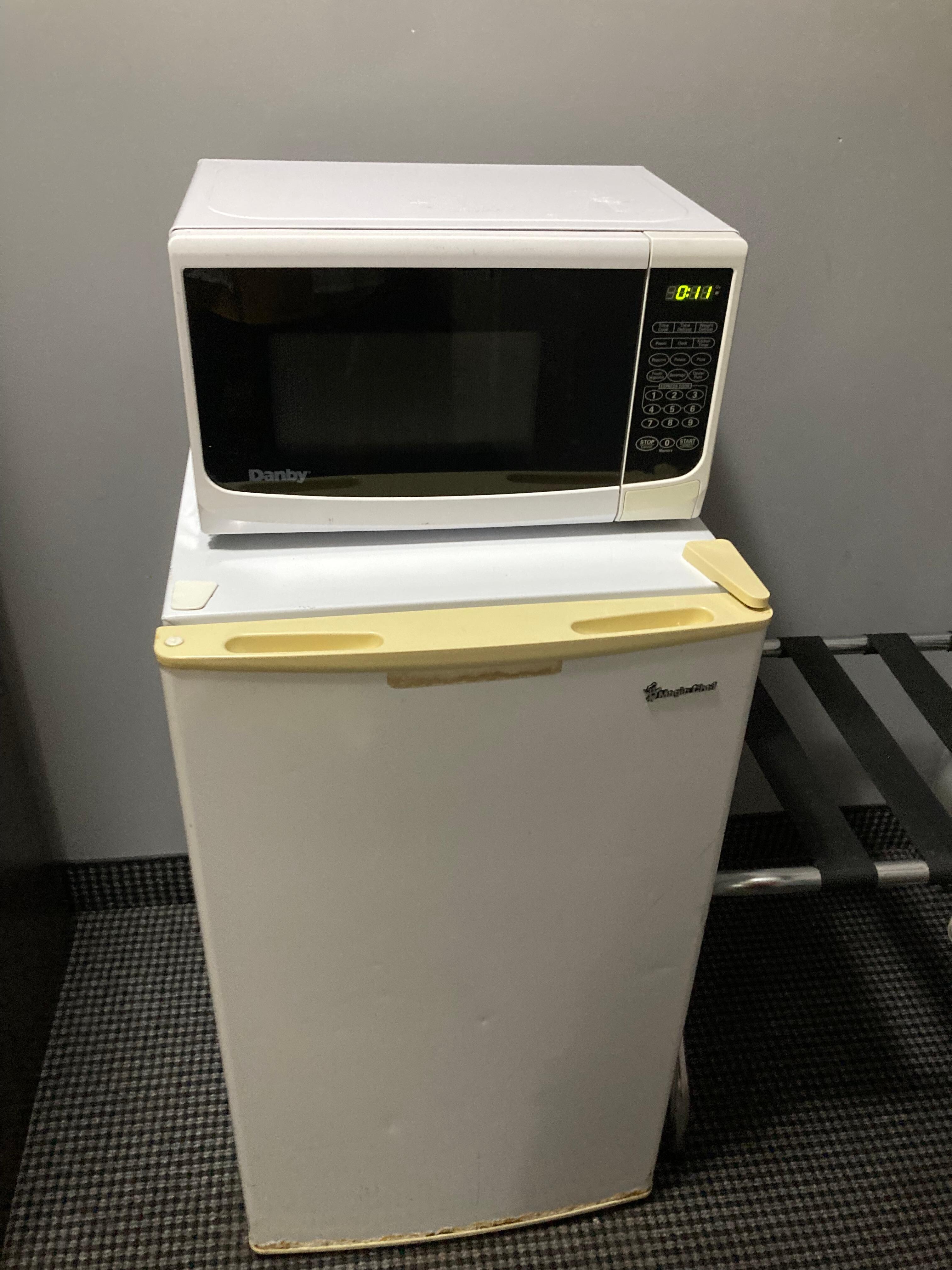 Microwave on top of yellow stained fridge