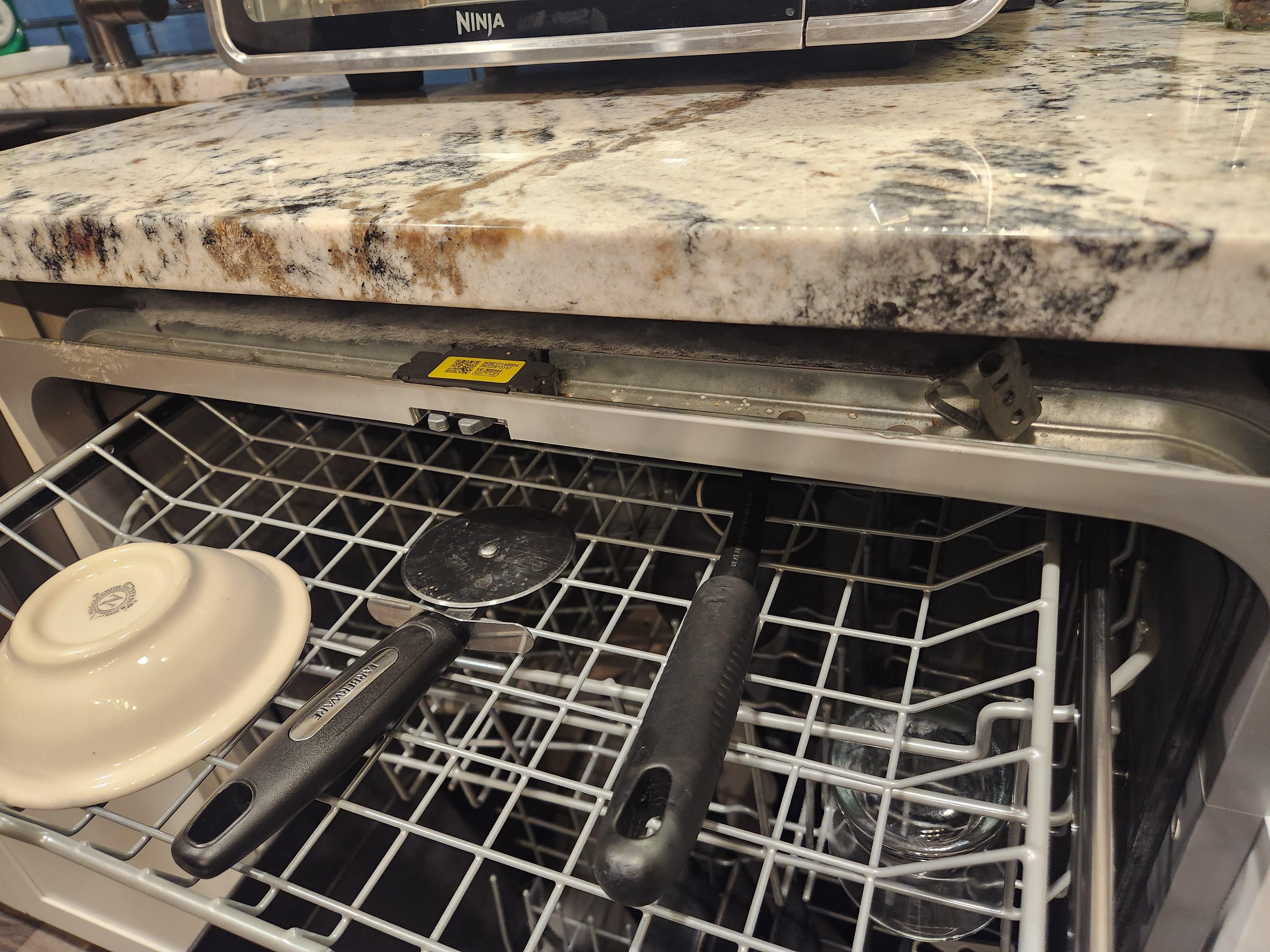 Dishwasher falls out of cabinet when shelves slide out