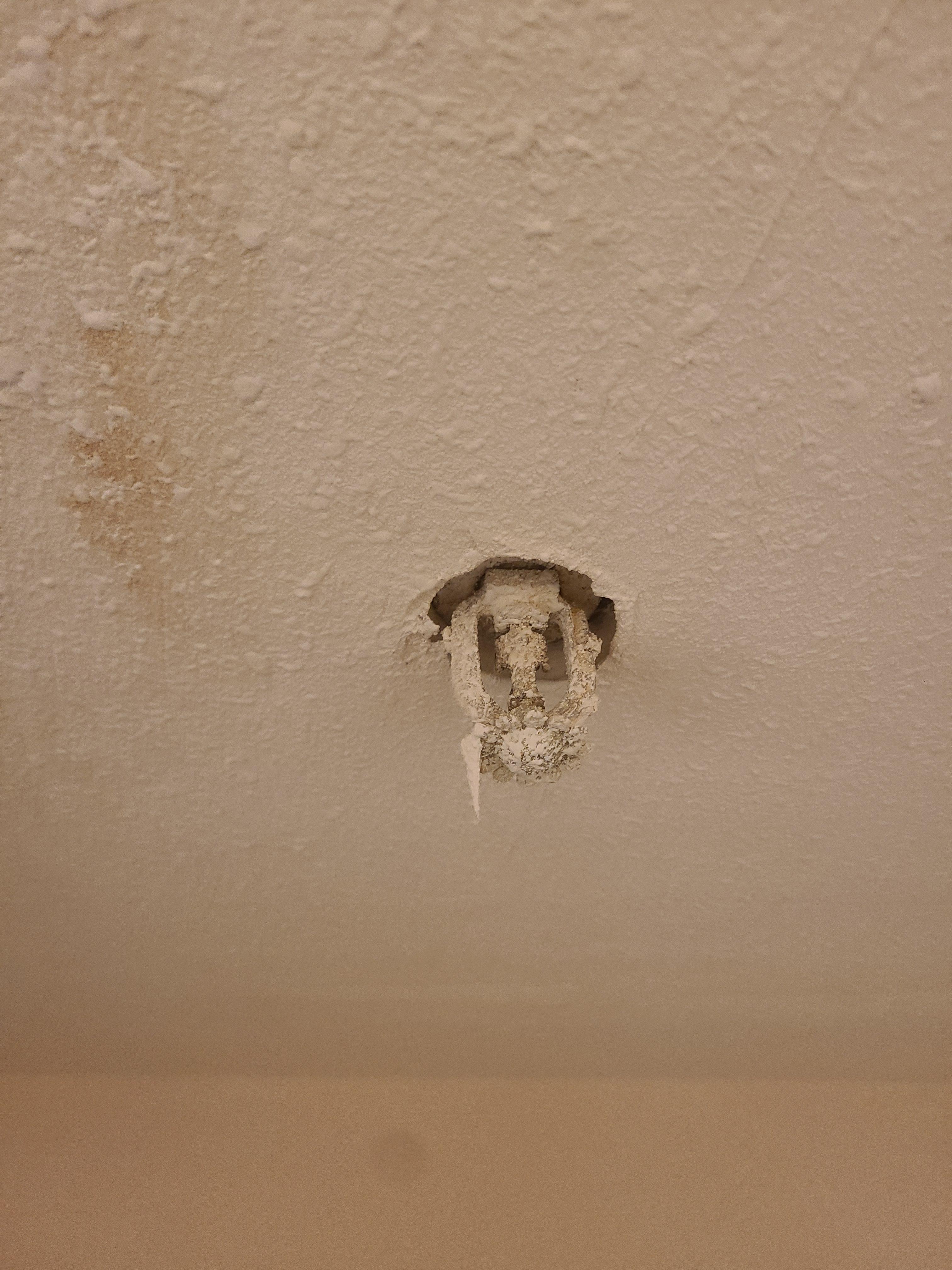 Exposed fire sprinkler covered in paint, likely reducing effectiveness.
