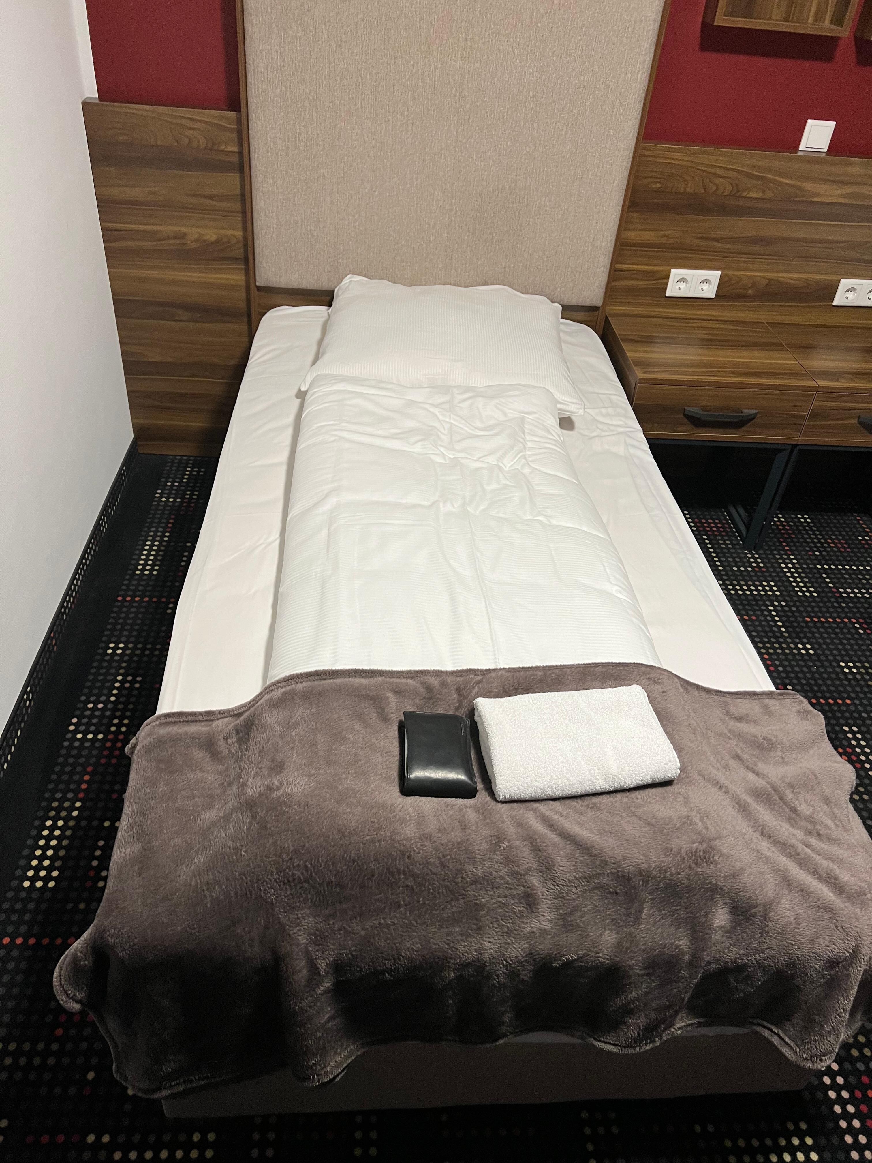 Look at the size of my wallet compared to the towel and the bed. Pay attention to the condition of the towel and the nature of the covers.
