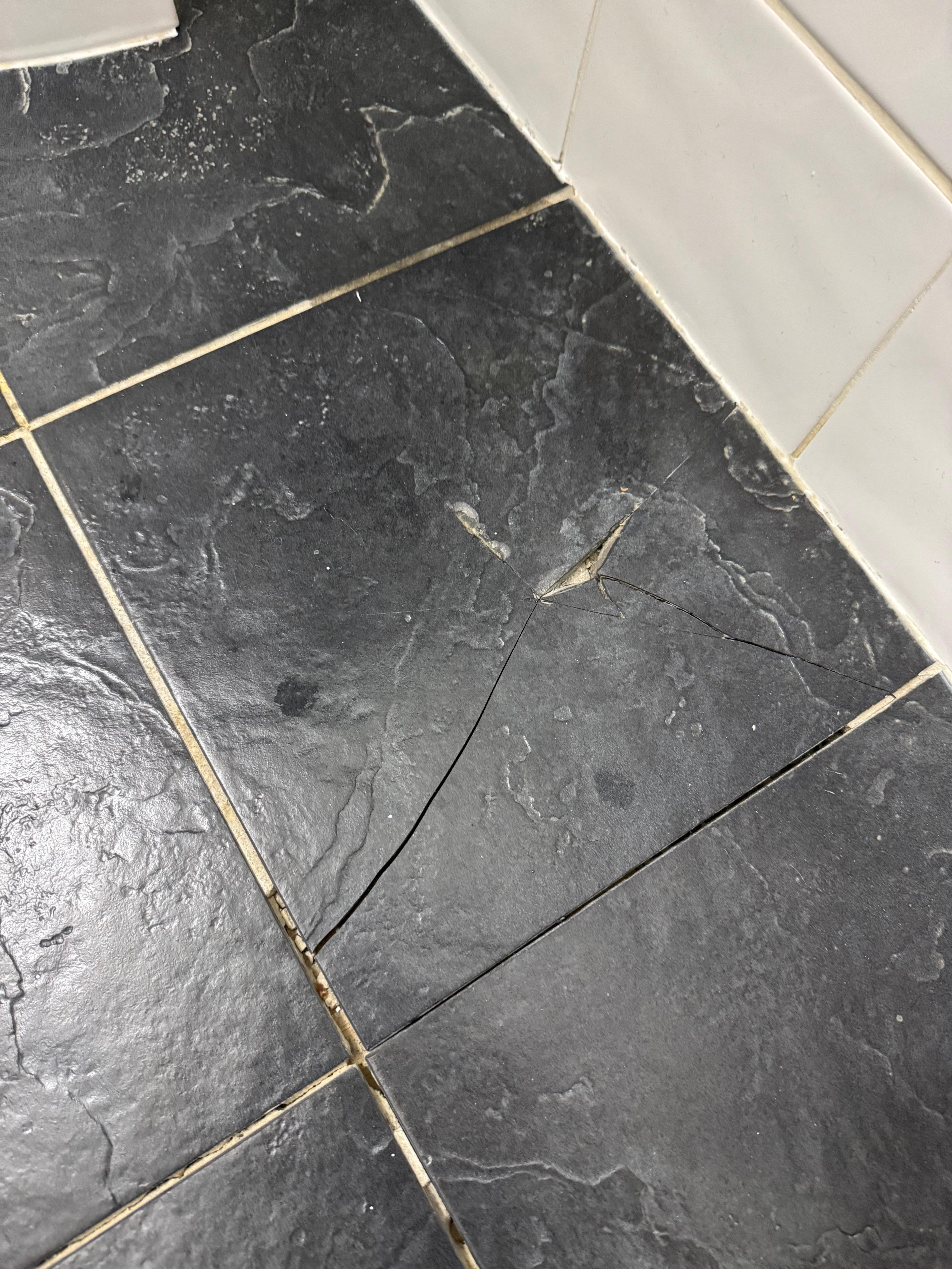 Dangerous broken stone tile on the bathroom floor.