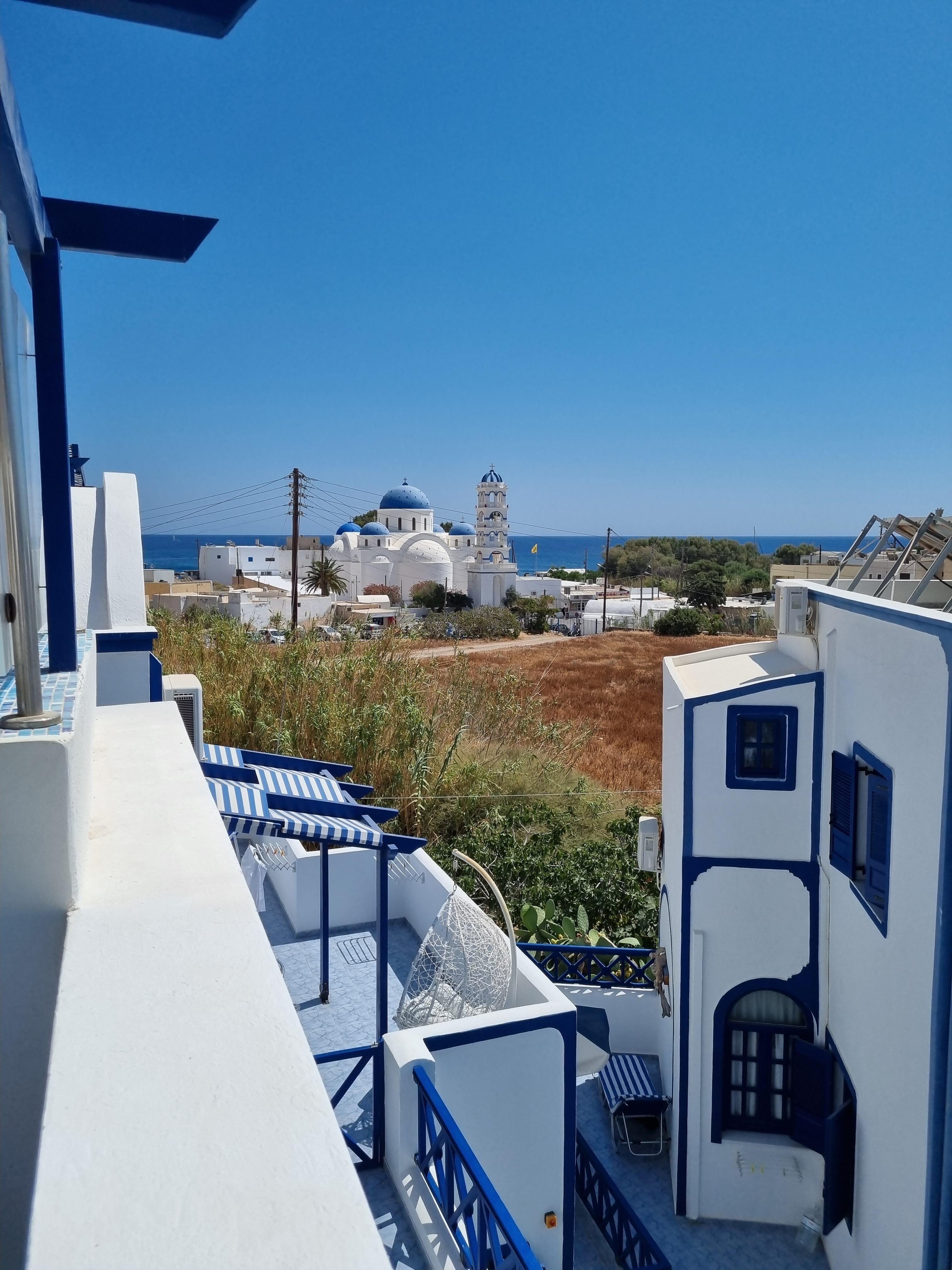 Vue depuis la terrasse (la mer en fond et les murs typiques des logements de l'hôtel en premier plan)