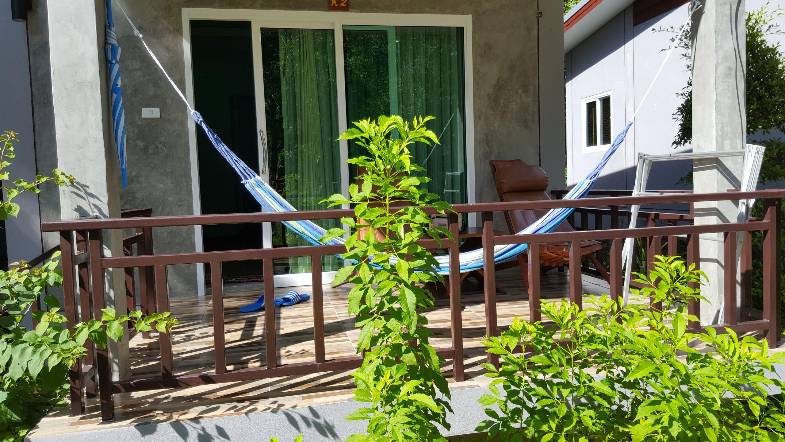 Petit bungalow avec terrasse hamac sur un jardin fleuri 