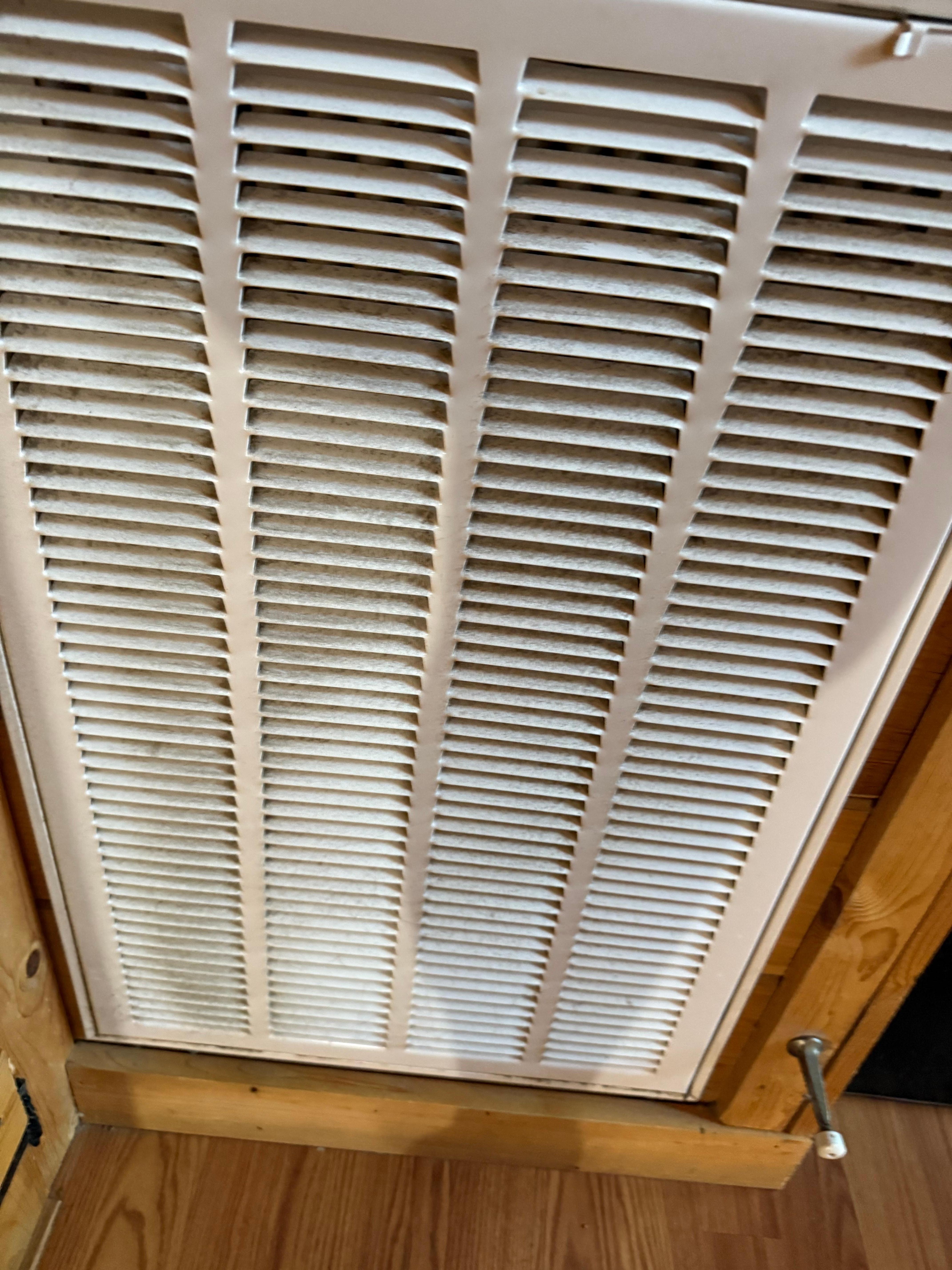 Vent in the living room, covered in black dust