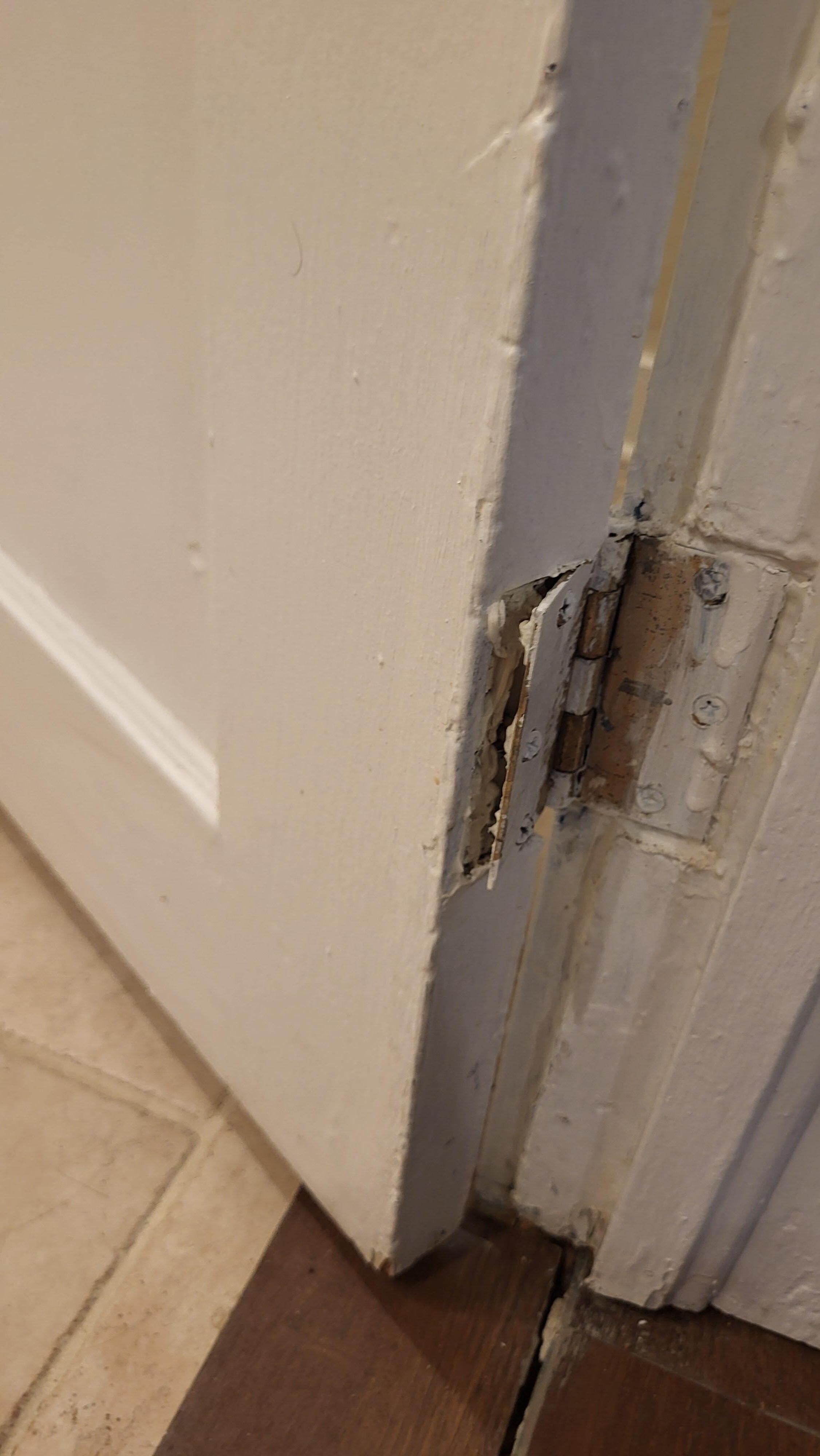 Downstairs en suite bathroom door bottom hinge not secured to door