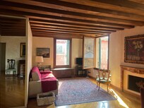 The living room overlooks the meandering canal on the right, and a bridge on the left. The light reflects the warm colours through the room making the space bright and still cosy.