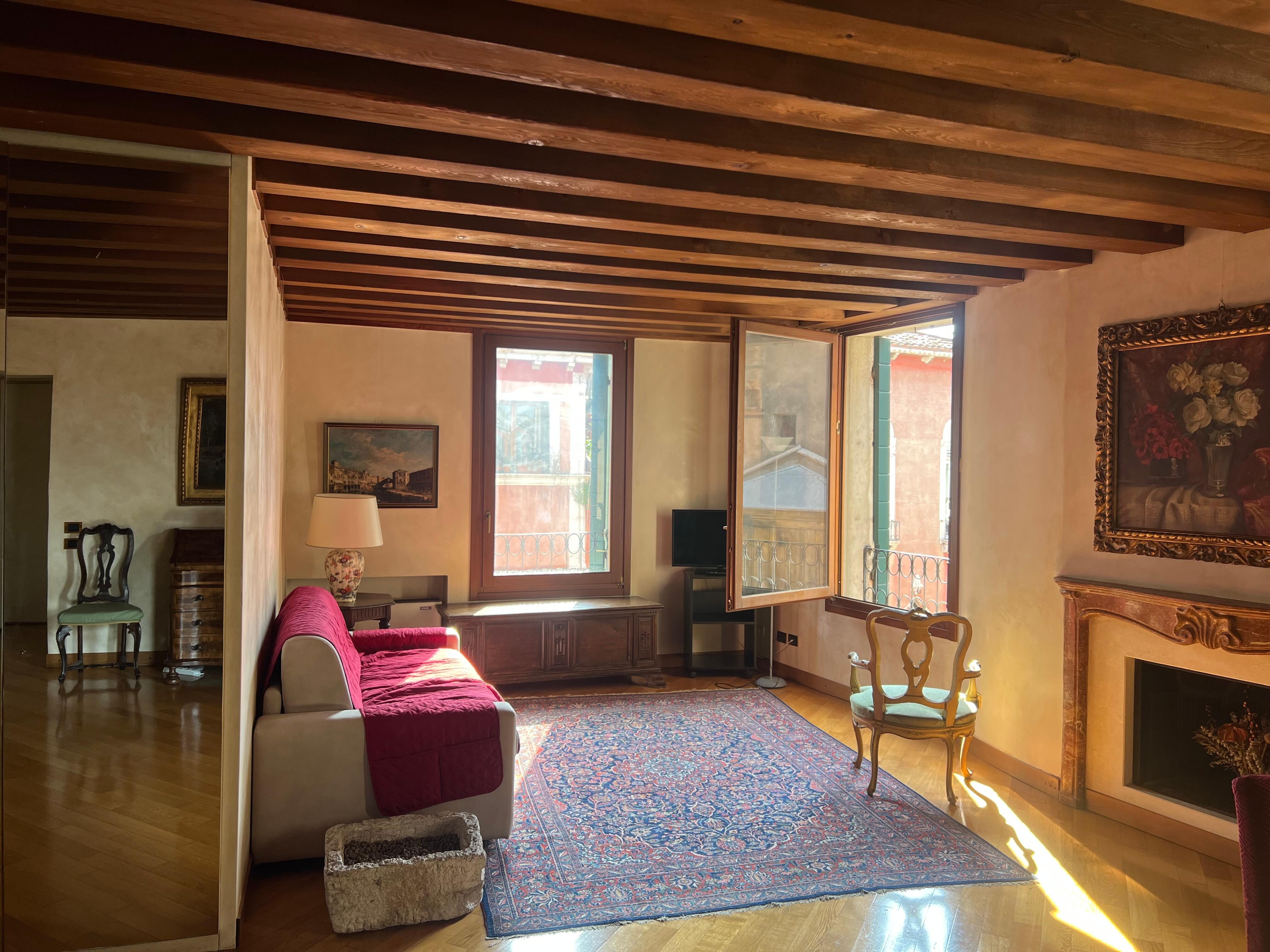 The living room overlooks the meandering canal on the right, and a bridge on the left. The light reflects the warm colours through the room making the space bright and still cosy. 