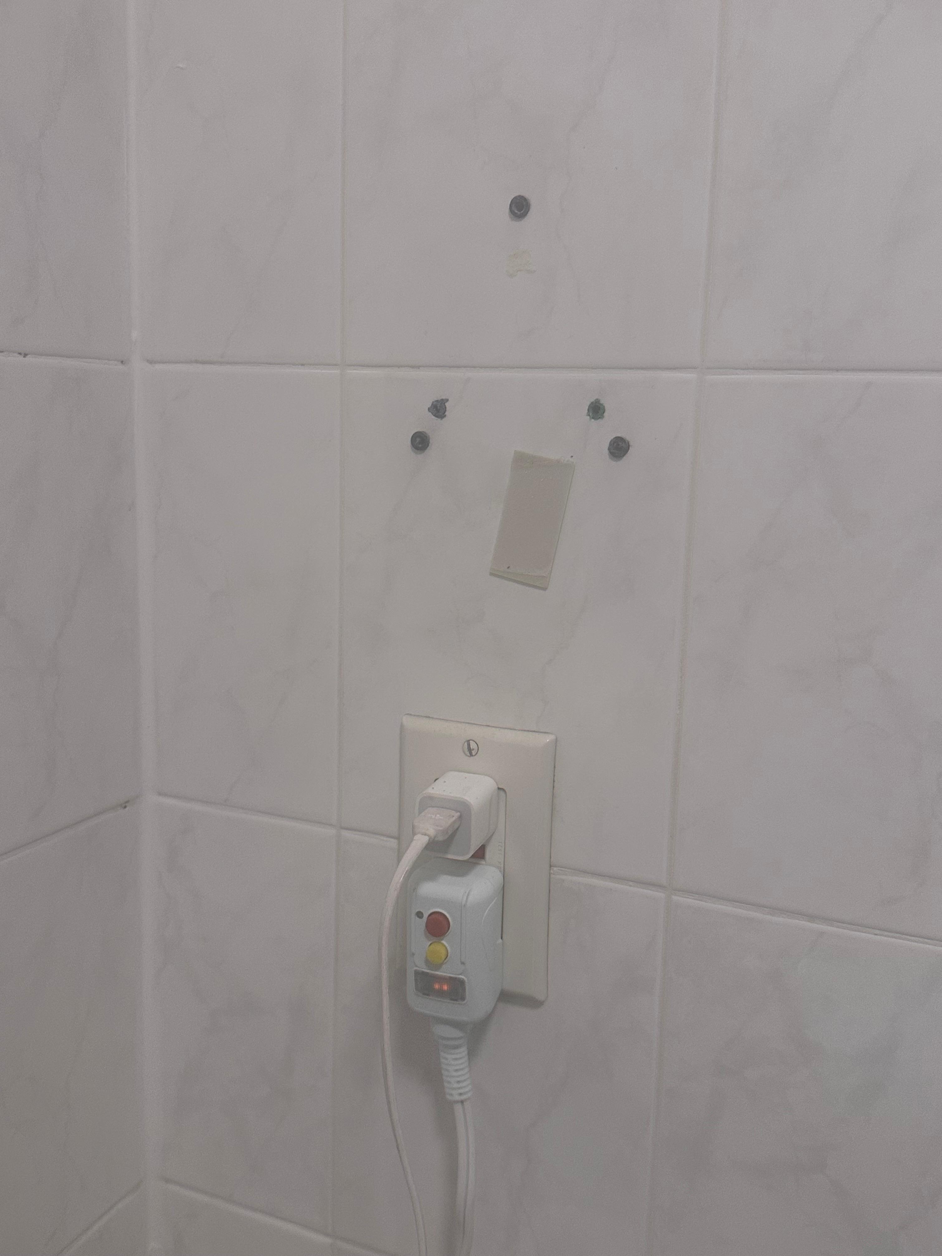 this is where they removed the broken hair dryer. they replaced the dryer but left in on the top of the toilet.