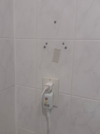 this is where they removed the broken hair dryer. they replaced the dryer but left in on the top of the toilet.