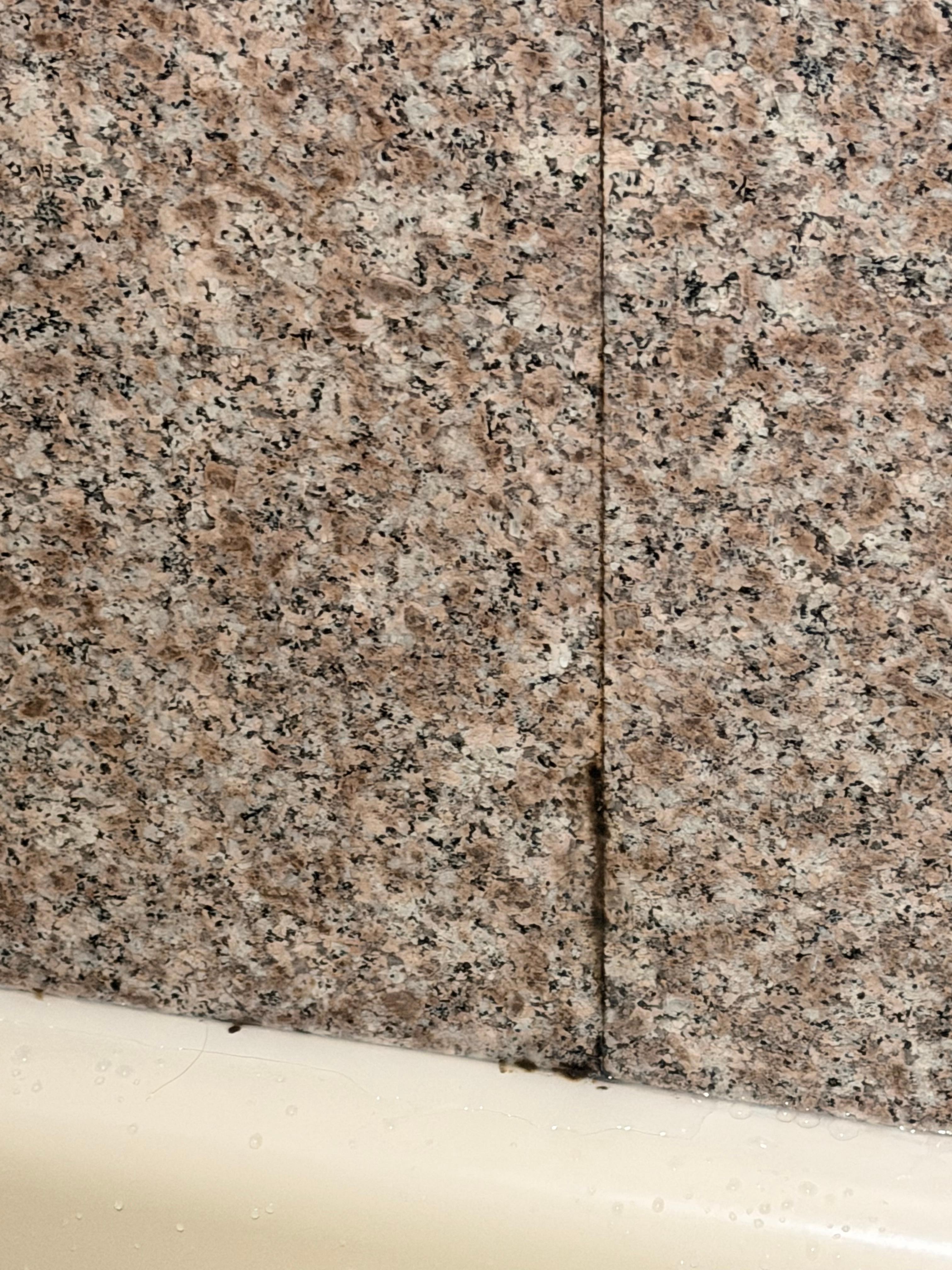 Heavy mildew accumulation in and around tub.