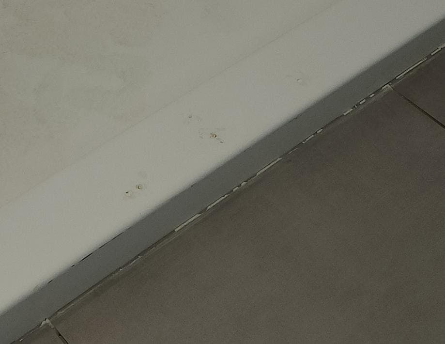 Damage and chunked out caulking and unclean step-in shower