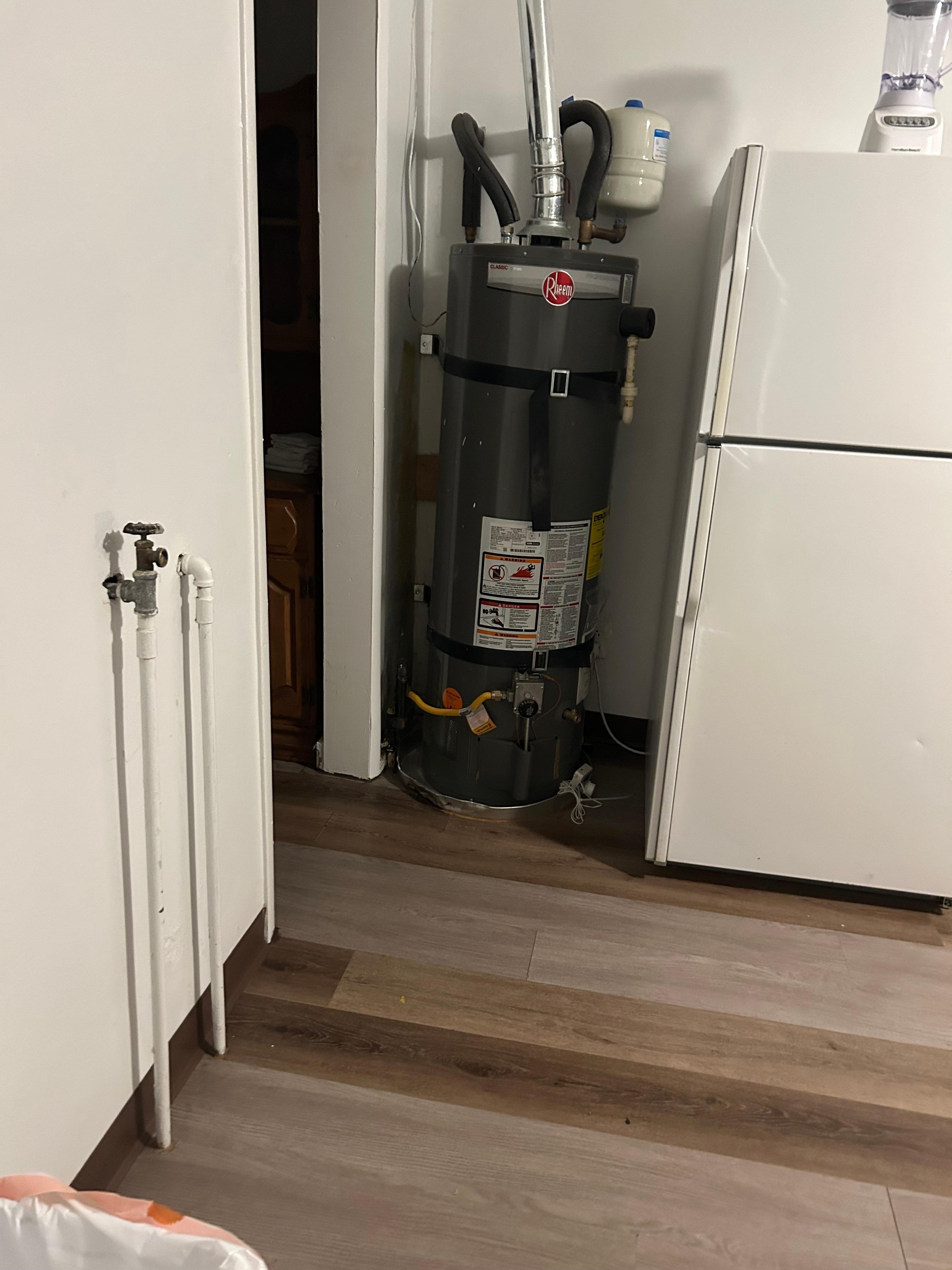 The water heater is located next to the refrigerator in the kitchen. There are pipes in a water Spicket in the kitchen on the wall. I have no idea what they’re for if they are safe.