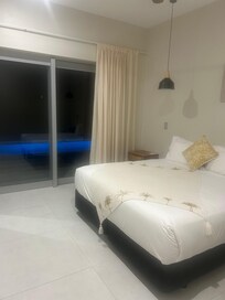 Main bedroom with pool in background at night